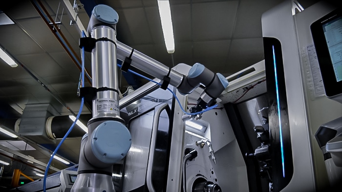 cobots pour chargement de machines CNC en train de charger des lopins dans une machine d'usinage