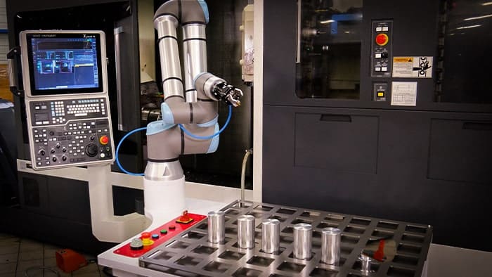 Cobot en train de superviser une machine (machine tending)